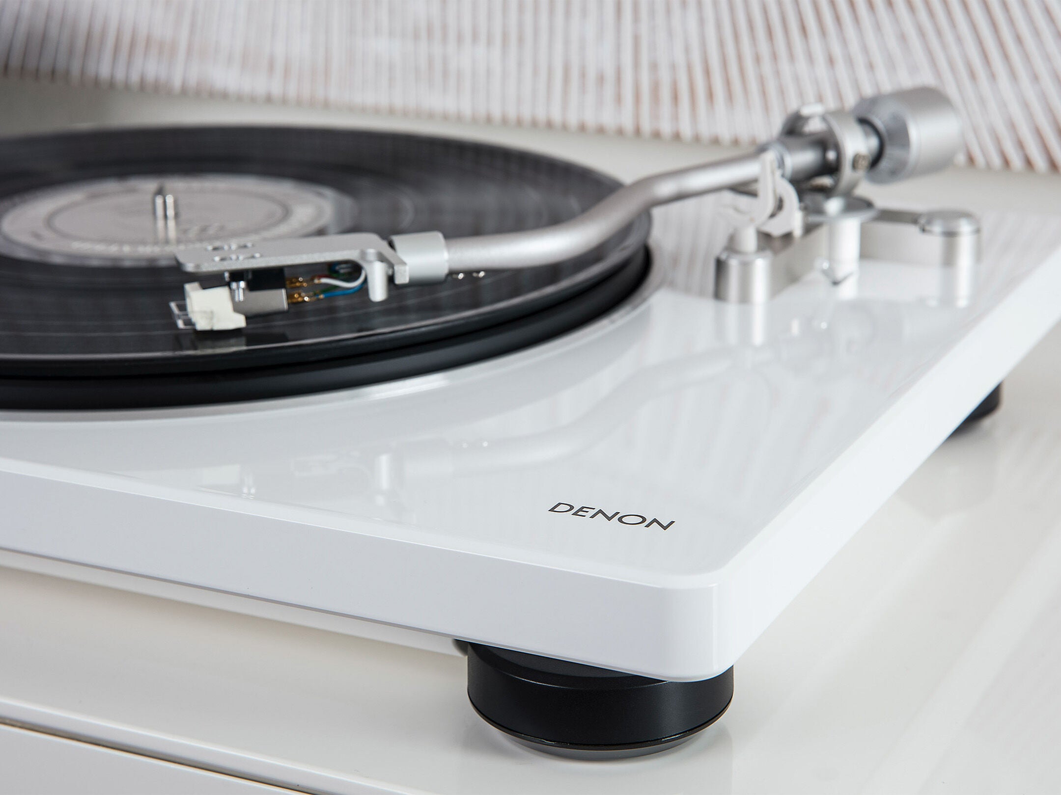Denon DP-400 Pick-Up alb, vedere laterală. Brațul tonearm și placa vinil sunt vizibile pe platan.