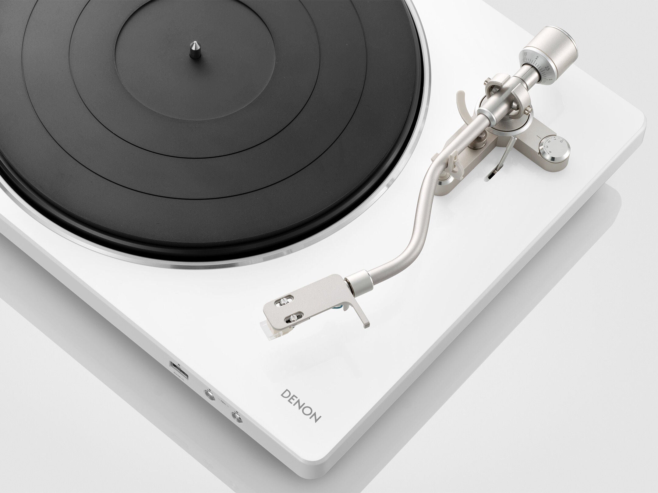 Denon DP-450USB Pick-Up în alb, vedere de sus, evidențiind brațul și platoul negru. Conectorii USB și audio vizibili.