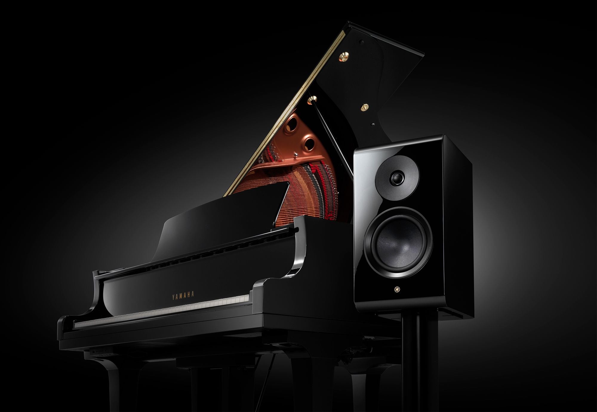 Yamaha NS-800A boxă neagră, vedere laterală alături de pian negru. Tweeter și woofer vizibile.