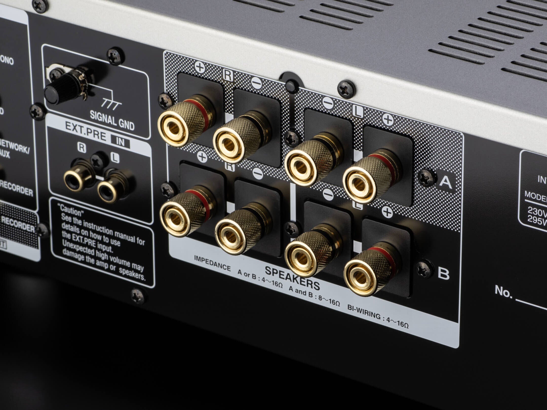 Terminale difuzoare Denon PMA-1700NE argintiu, conexiuni bi-wiring și impedanță vizibile din spate.
