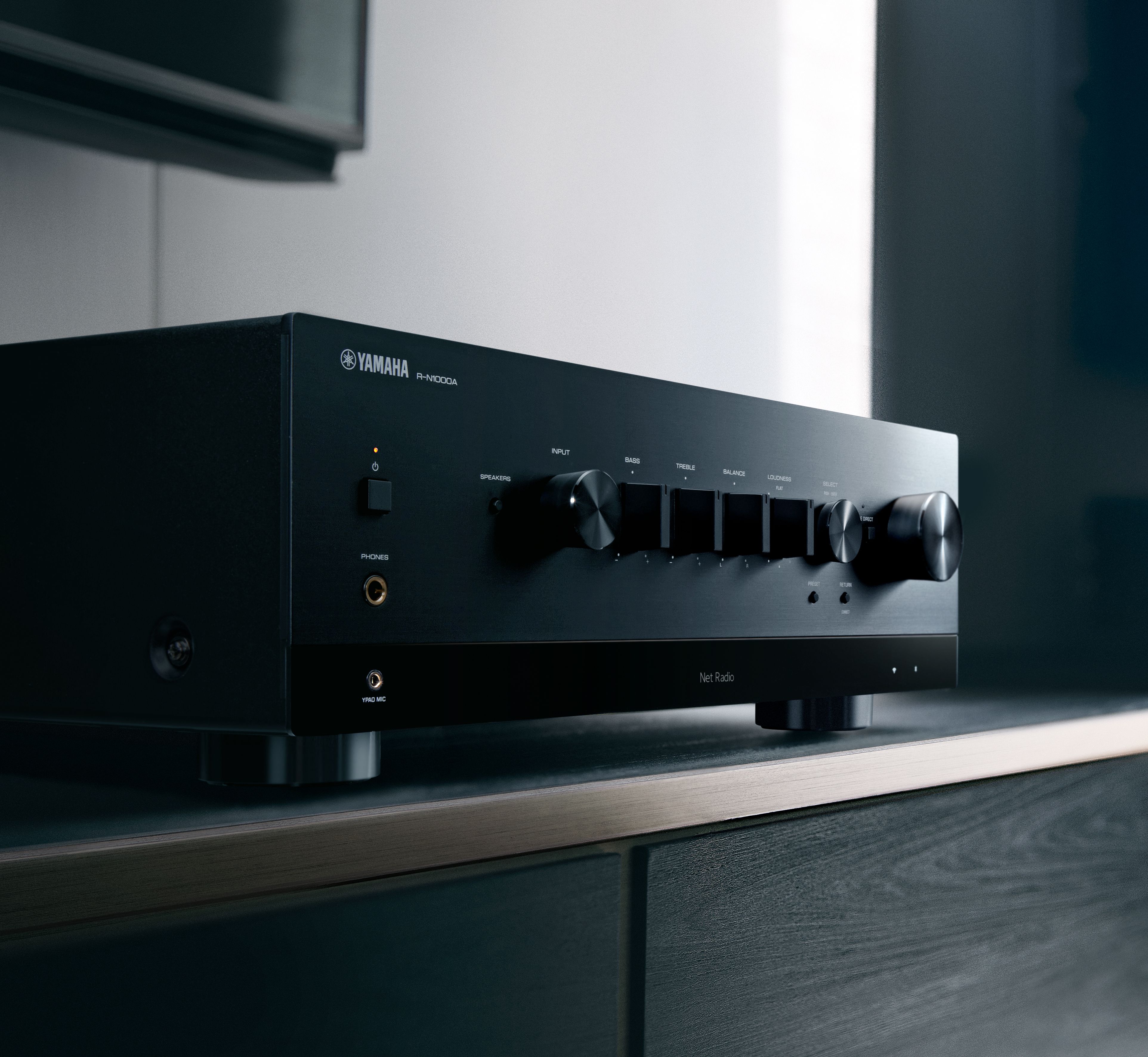 Yamaha R-N1000A Receiver AV, vedere laterală, culoare neagră, butoane de control și intrări audio vizibile.