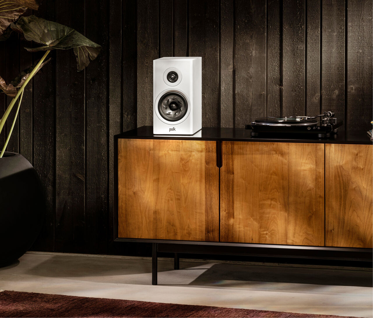 Polk Audio Reserve R200 alb, plasat pe un dulap din lemn, lângă un pickup, în decor interior elegant.