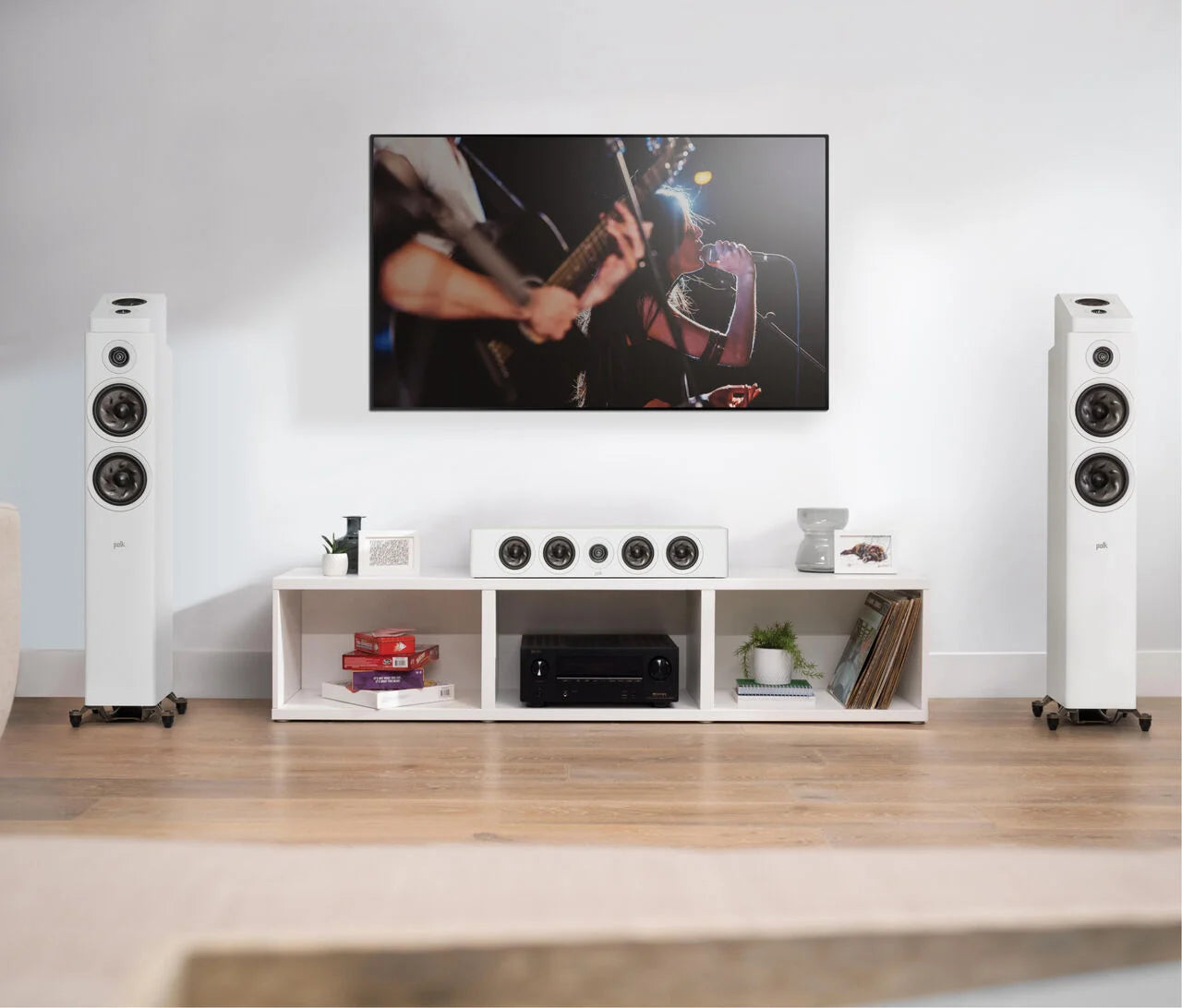 Boxe Polk Audio Reserve R900HT albe, amplasate într-un living, lângă un televizor. Sistem audio complet.
