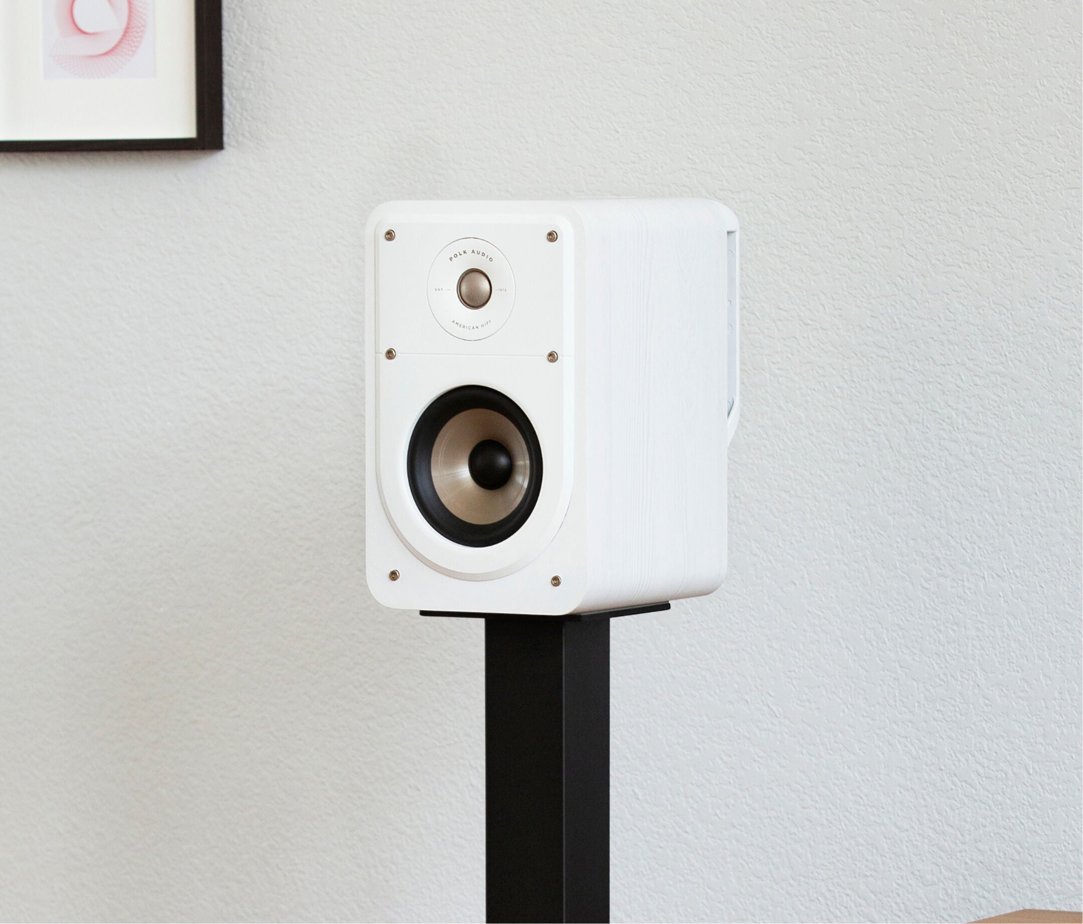 Boxa albă Polk Audio Signature Elite ES15, vedere laterală, montată pe suport negru, într-un mediu interior.