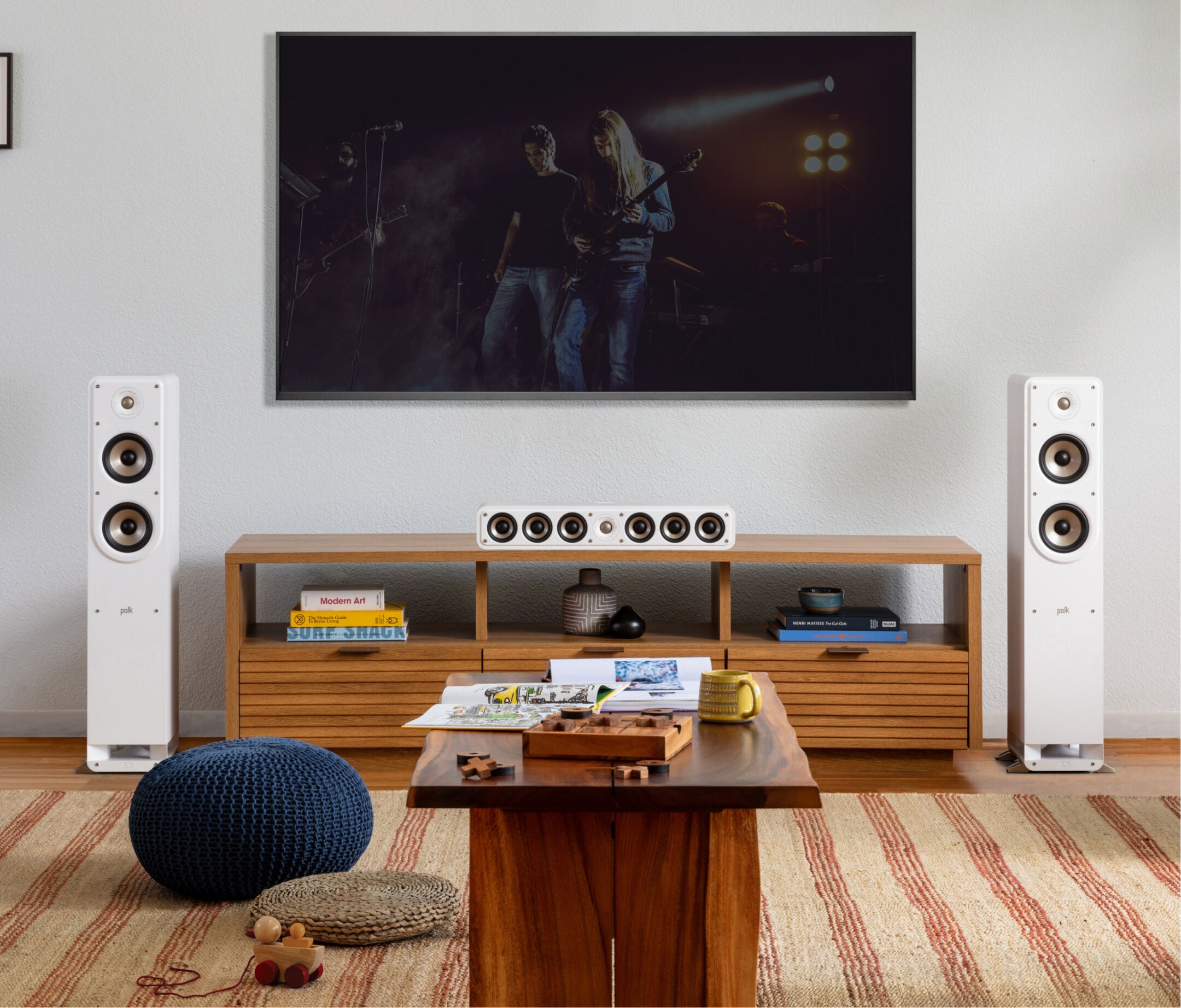 Boxe de podea Polk Audio Signature Elite ES50 albe, plasate într-un living modern, lângă un sistem audio.