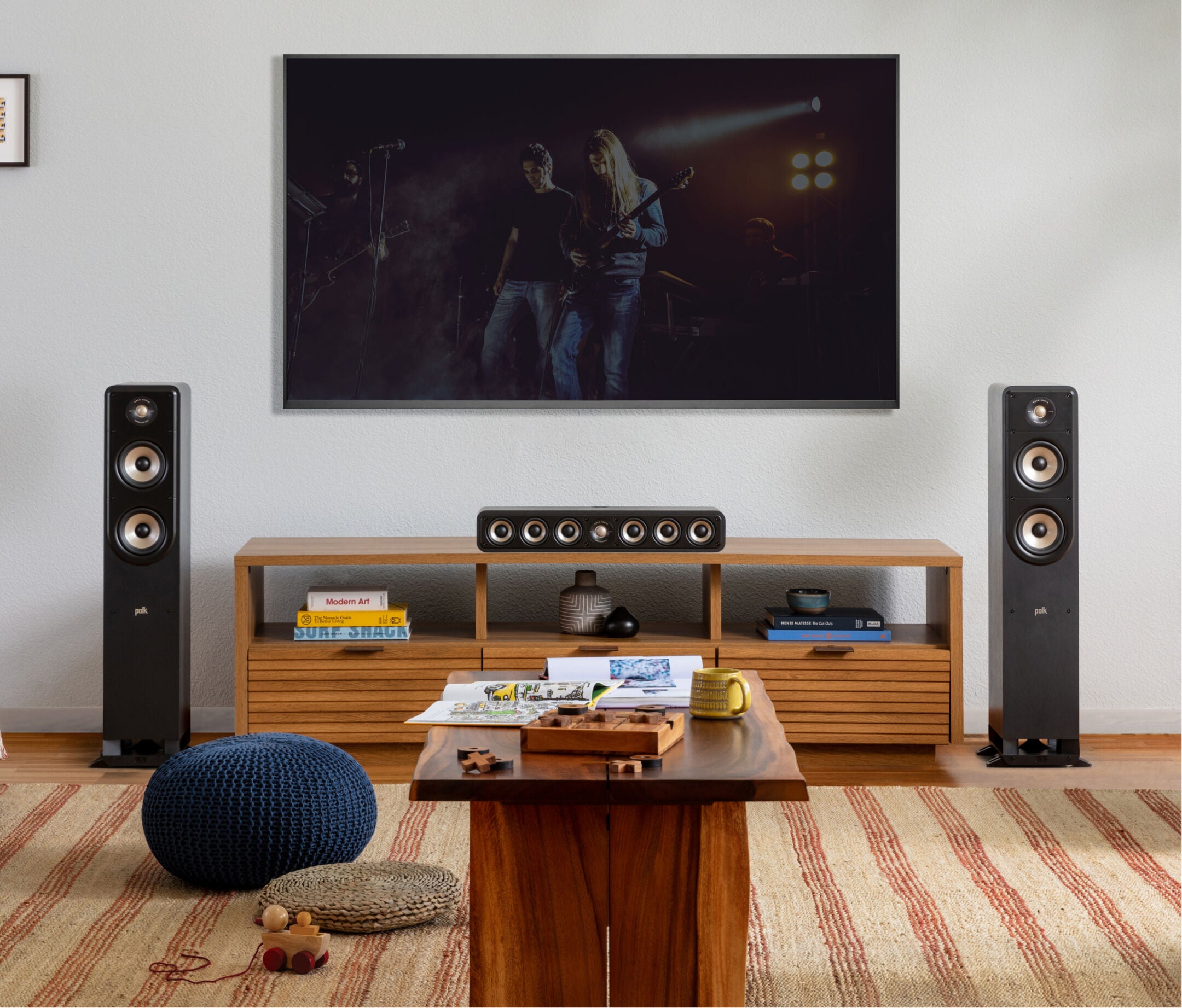 Boxe de podea Polk Audio Signature Elite ES50 negre, amplasate într-un living modern, lângă un televizor.
