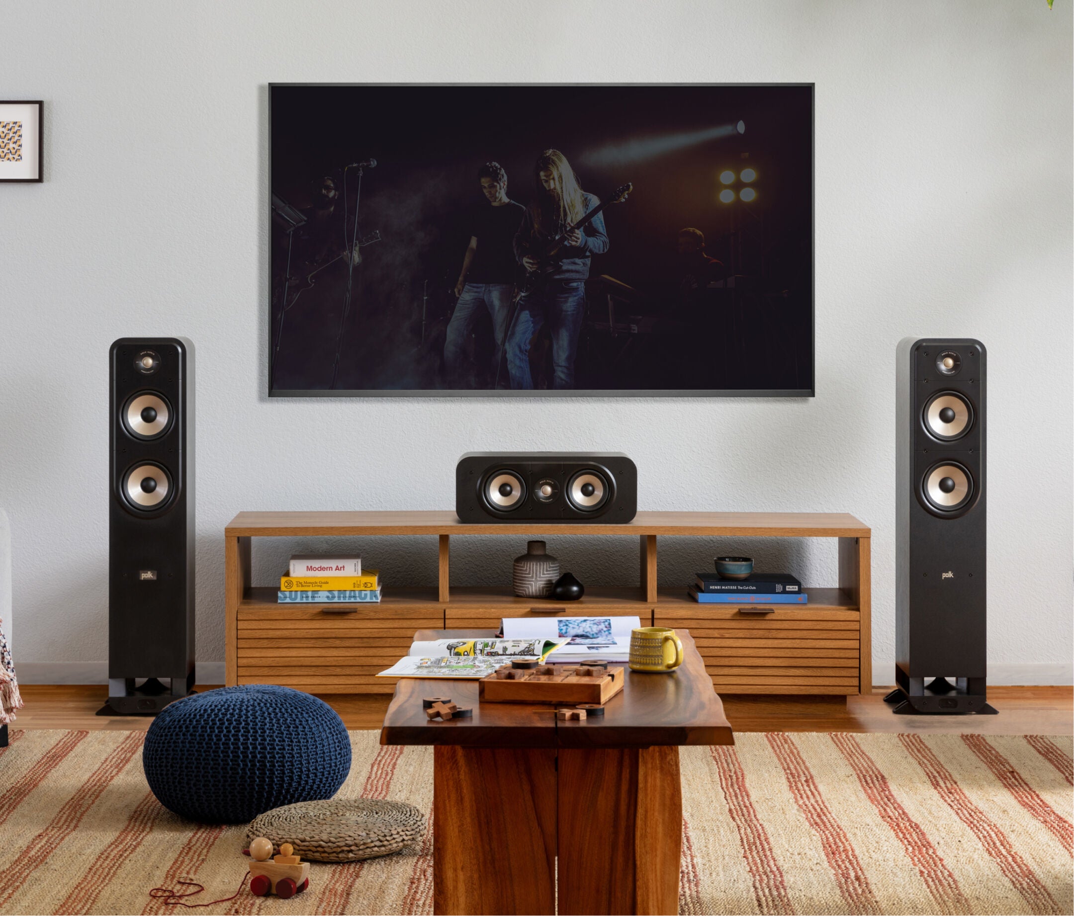Boxe de podea Polk Audio Signature Elite ES55 negre, amplasate într-un living modern, lângă un televizor.