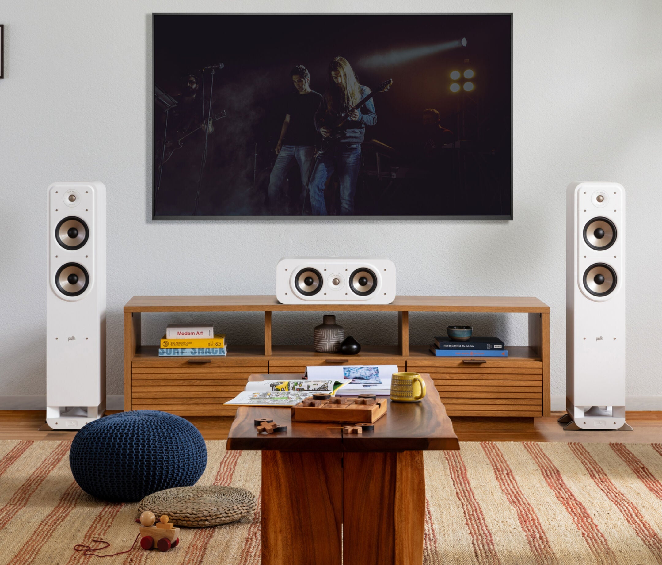 Boxe de podea Polk Audio Signature Elite ES55 albe, plasate în sufragerie, lângă un centru media.