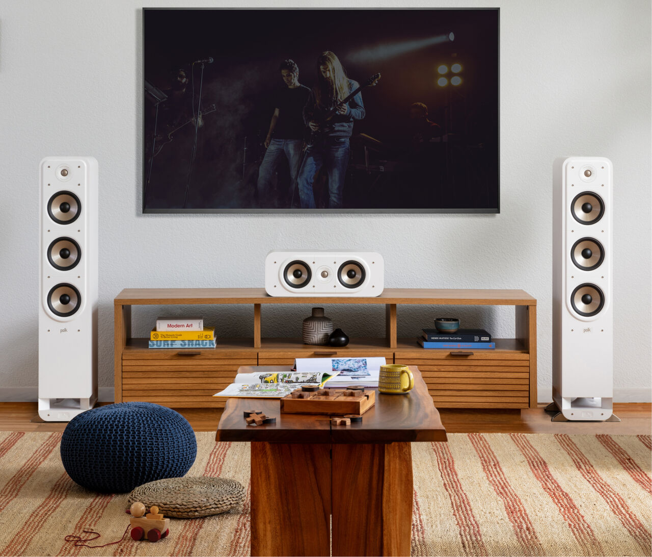 Boxe de podea Polk Audio Signature Elite ES60 albe, amplasate în sufragerie, lângă mobilier din lemn.
