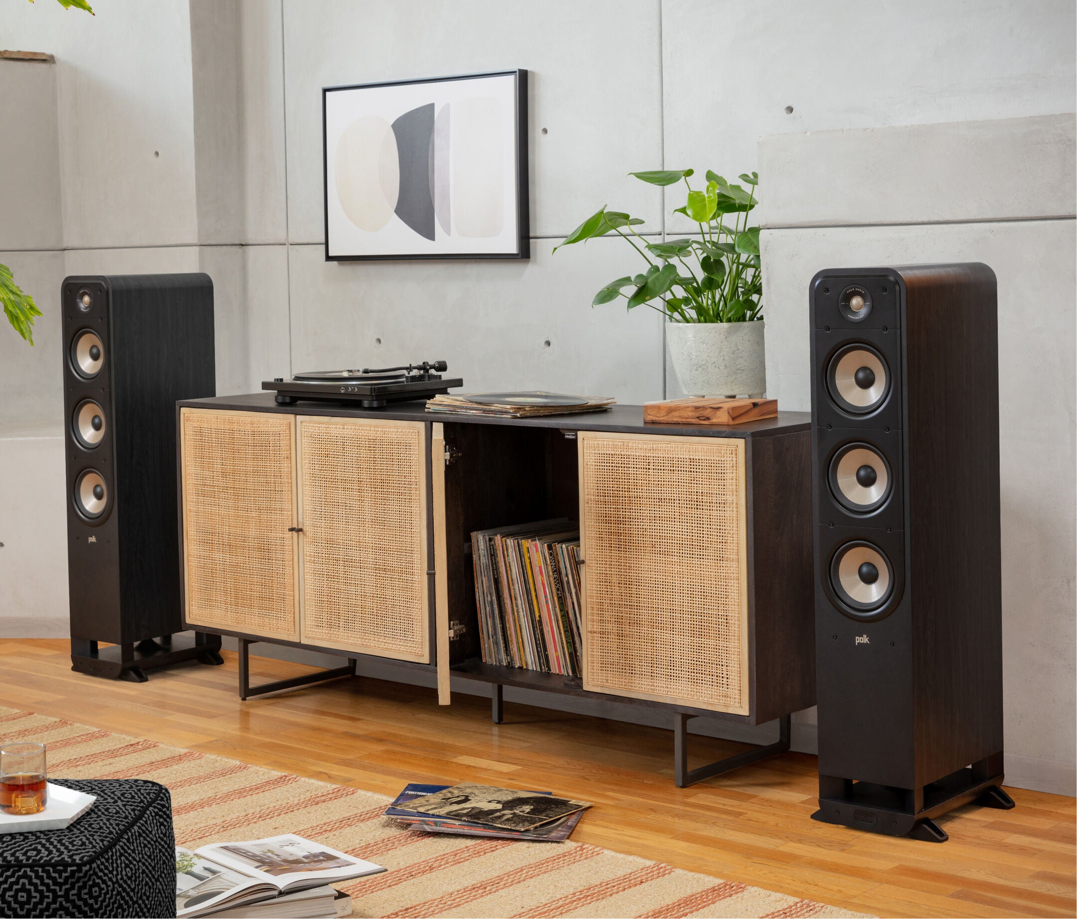 Boxe de podea Polk Audio Signature Elite ES60 negre, amplasate lângă mobilier, cu trei difuzoare vizibile.