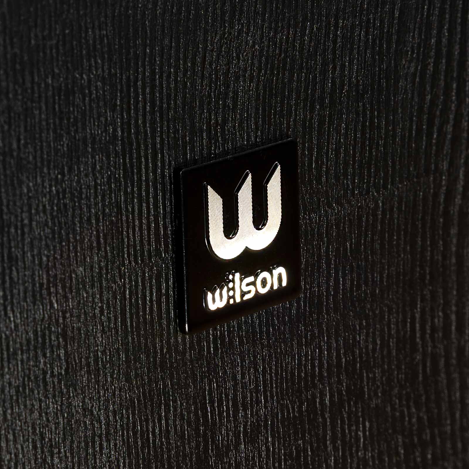 Logo Wilson pe partea laterală a boxei de podea Wilson Studio 7, finisaj negru detaliat, textură lemnoasă.