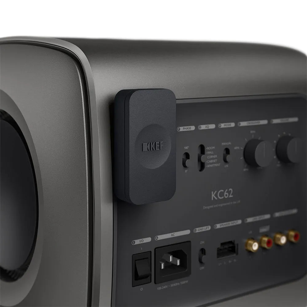 Subwoofer KEF KC62 1000W gri, vedere laterală spate cu panou de control, conexiuni RCA și alimentare.