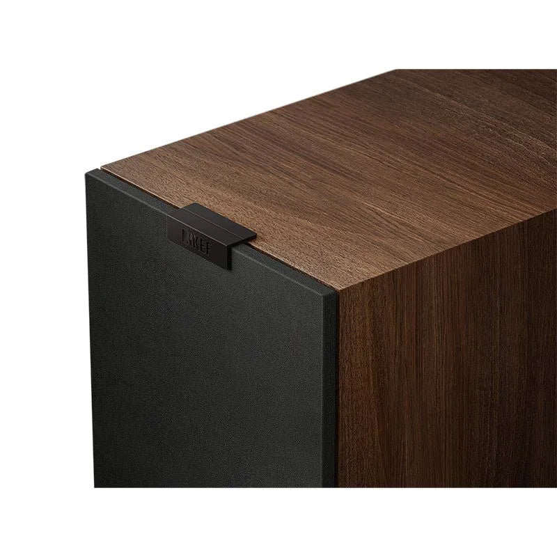Colț frontal boxă KEF Q11 Meta în finisaj nuc, grilaj frontal textil negru vizibil, logo KEF metalic sus.