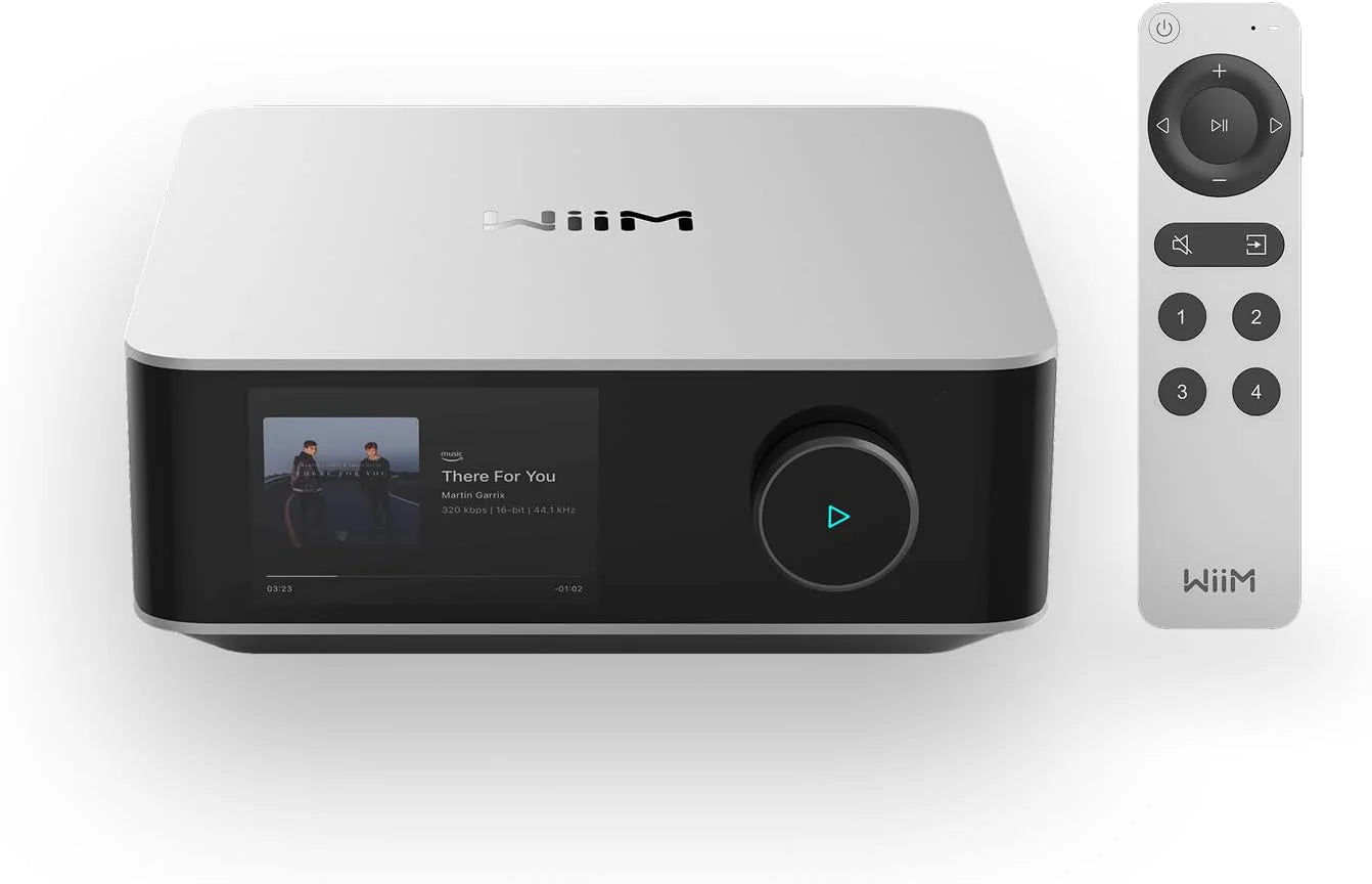 WiiM Amp Ultra Amplificator argintiu, vedere frontală cu ecran activ, buton rotativ și telecomandă inclusă.