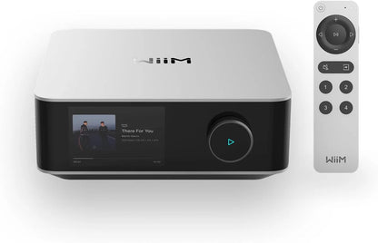 WiiM Amp Ultra Amplificator argintiu, vedere frontală cu ecran activ, buton rotativ și telecomandă inclusă.