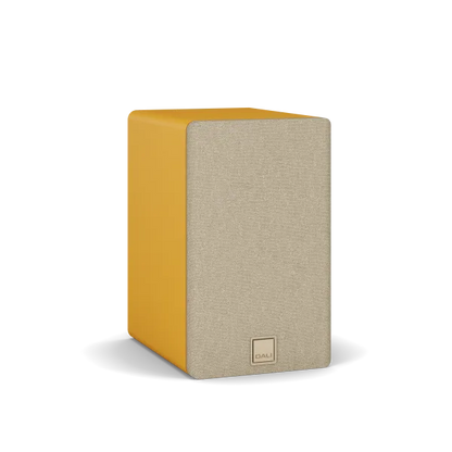 Boxă de raft Dali Kupid Golden Yellow, vedere frontală-stânga, grilaj textil bej și logo DALI vizibil.