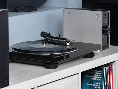 Denon DP-400 Pick-Up negru, vedere laterală, plasat pe raft. Brațul și platanul sunt vizibile clar.