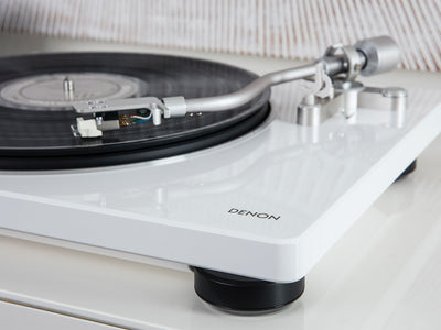 Denon DP-400 Pick-Up alb, vedere laterală. Brațul tonearm și placa vinil sunt vizibile pe platan.