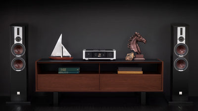 Amplificator NAD M33 argintiu, vedere frontală, ecran central activ, buton volum dreapta, raft media.