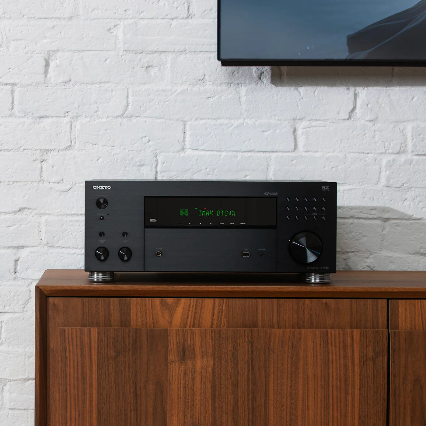 Receiver AV Onkyo TX-RZ30 negru, vedere frontală pe consolă din lemn, afișaj IMAX DTS:X activ.