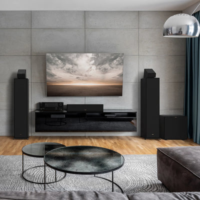 Boxe de podea Klipsch R-600F negre amplasate într-un sistem home theater modern cu TV montat pe perete.