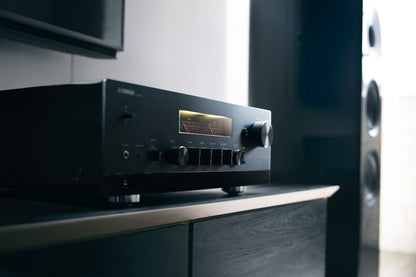 Receiver AV Yamaha R-N2000A, vedere laterală, culoare neagră, afișaj iluminat, butoane de control vizibile.