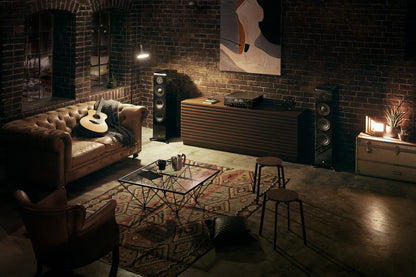 Receiver Yamaha R-N2000A amplasat într-o cameră de living, culoare neagră, cu boxe și mobilier retro.