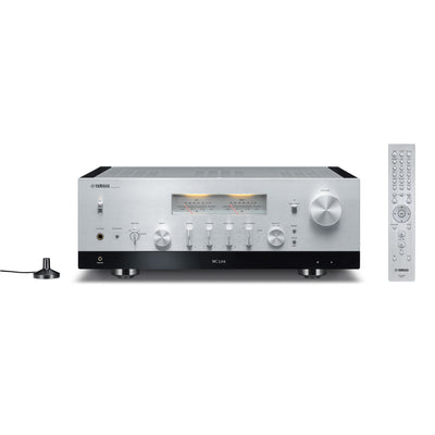 Yamaha R-N2000A Receiver AV argintiu, vedere frontală, afișaj analogic, butoane control, telecomandă inclusă.