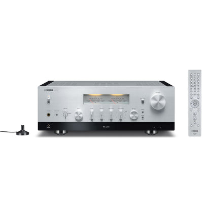 Yamaha R-N2000A Receiver AV argintiu, vedere frontală, afișaj analogic, butoane control, telecomandă inclusă.