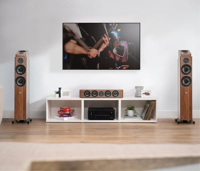 Boxe Polk Audio Reserve R900HT maro, amplasate în cameră de zi, lângă un sistem home theater.