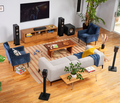 Boxe Polk Audio Signature Elite ES10 negre, așezate în sufragerie, lângă televizor și mobilier din lemn.