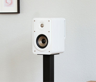 Boxa albă Polk Audio Signature Elite ES15, vedere laterală, montată pe suport negru, într-un mediu interior.