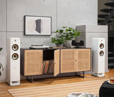 Boxe de podea Polk Audio Signature Elite ES55 albe, amplasate lângă un mobilier modern, cu două difuzoare vizibile.