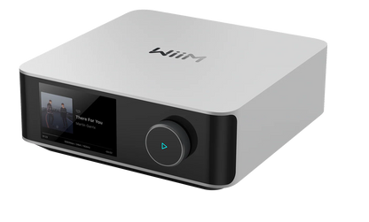 WiiM Amp Ultra Amplificator argintiu, vedere frontală din dreapta, afișaj activ și buton volum iluminat.