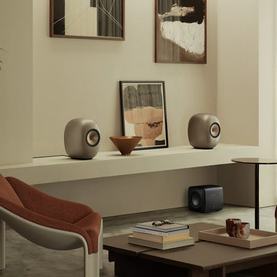 KEF LS Luxe Dusk Titanium așezate pe un raft, într-un living.